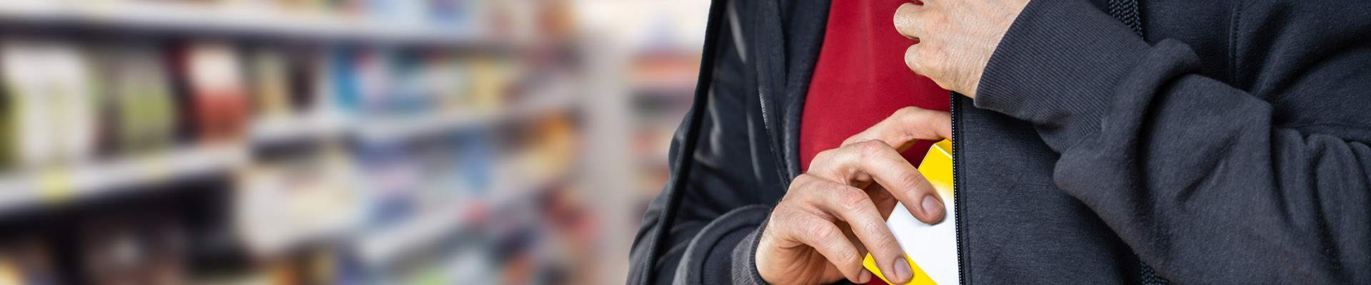 image of shoplifting man sneaking item into jacket